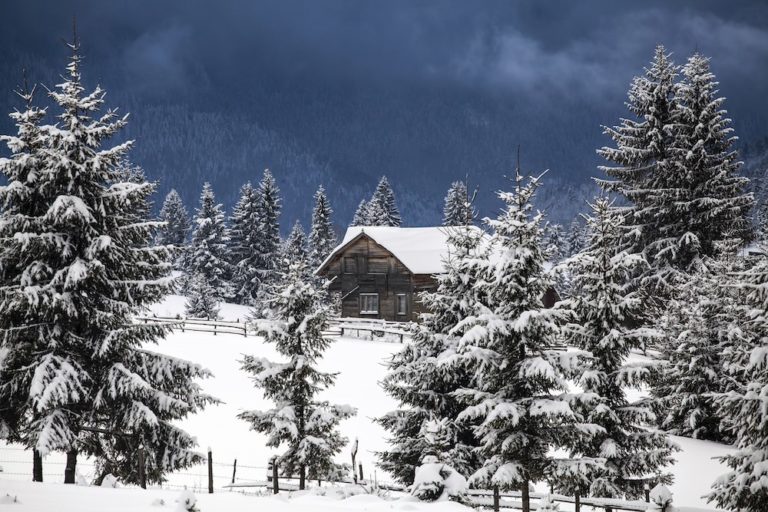 Fairy winter landscape in the Carpathian Mountains. Snow covered small mountain village.